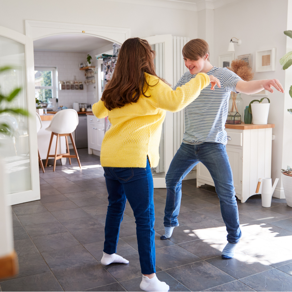 Girl and boy dancing in living room of a house