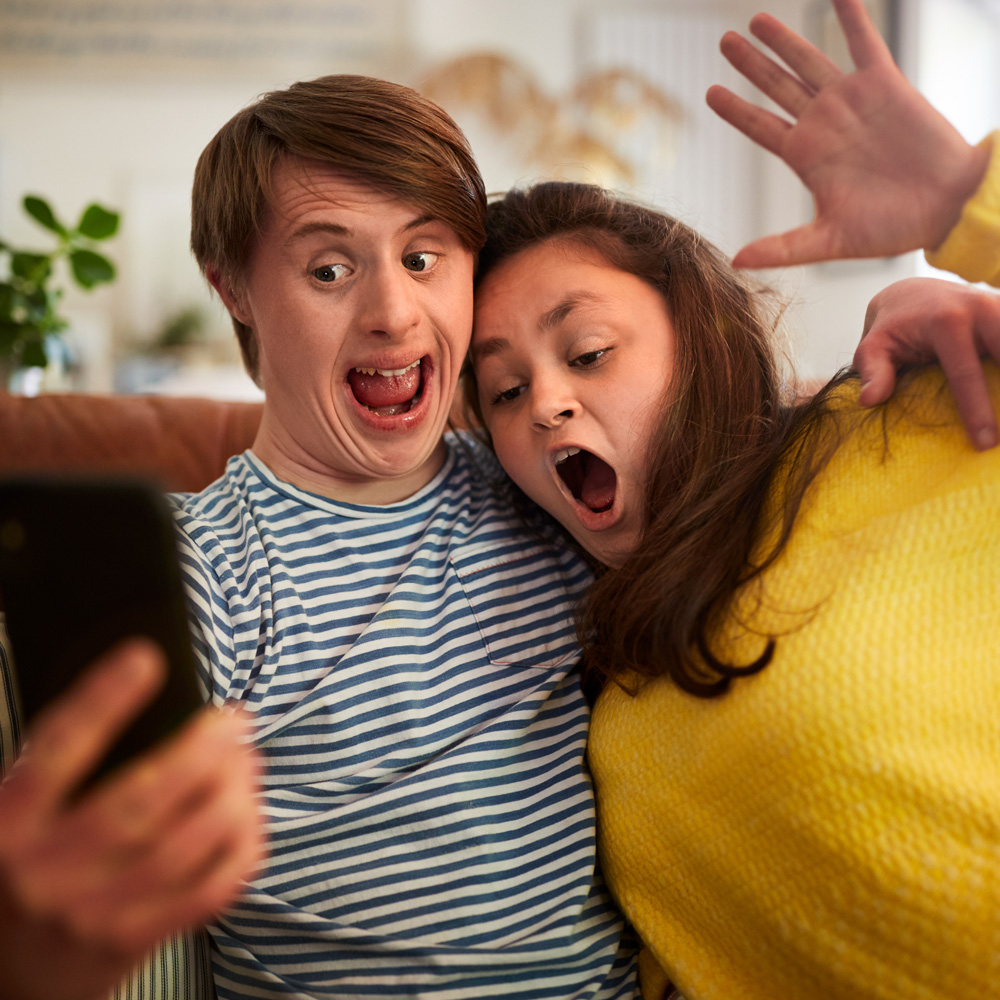 Girl and boy taking a photograph of themselves on a mobile phone