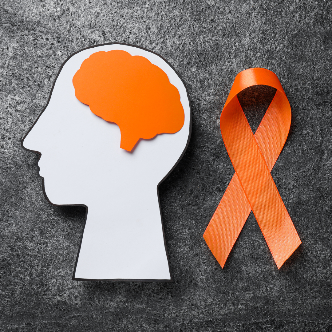 Two smiling young adults with disabilities sitting together outdoors