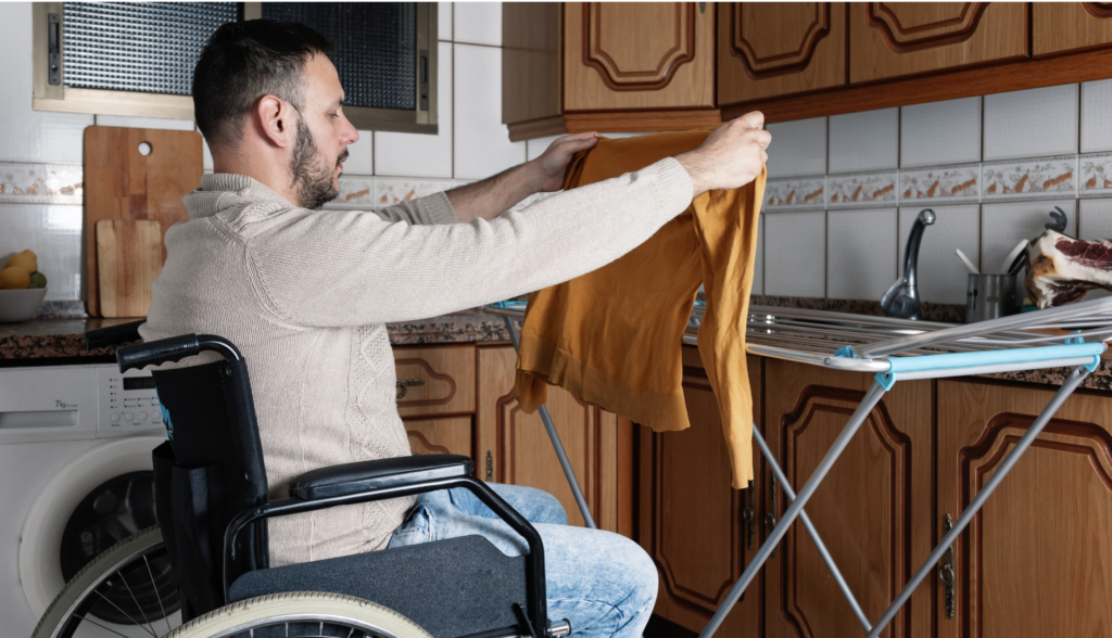 Man in wheelchair doing laundry at home – Aspire Hub support independent living