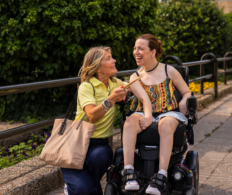 Support worker walking beside a woman using a wheelchair